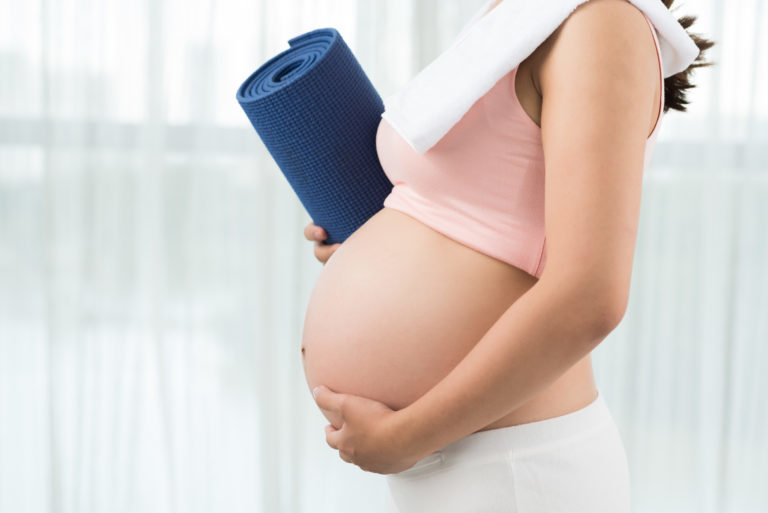 Pregnant woman with exercise mat